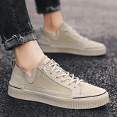 Beige low-top sneakers with suede and canvas panels, casual fit, worn with black jeans