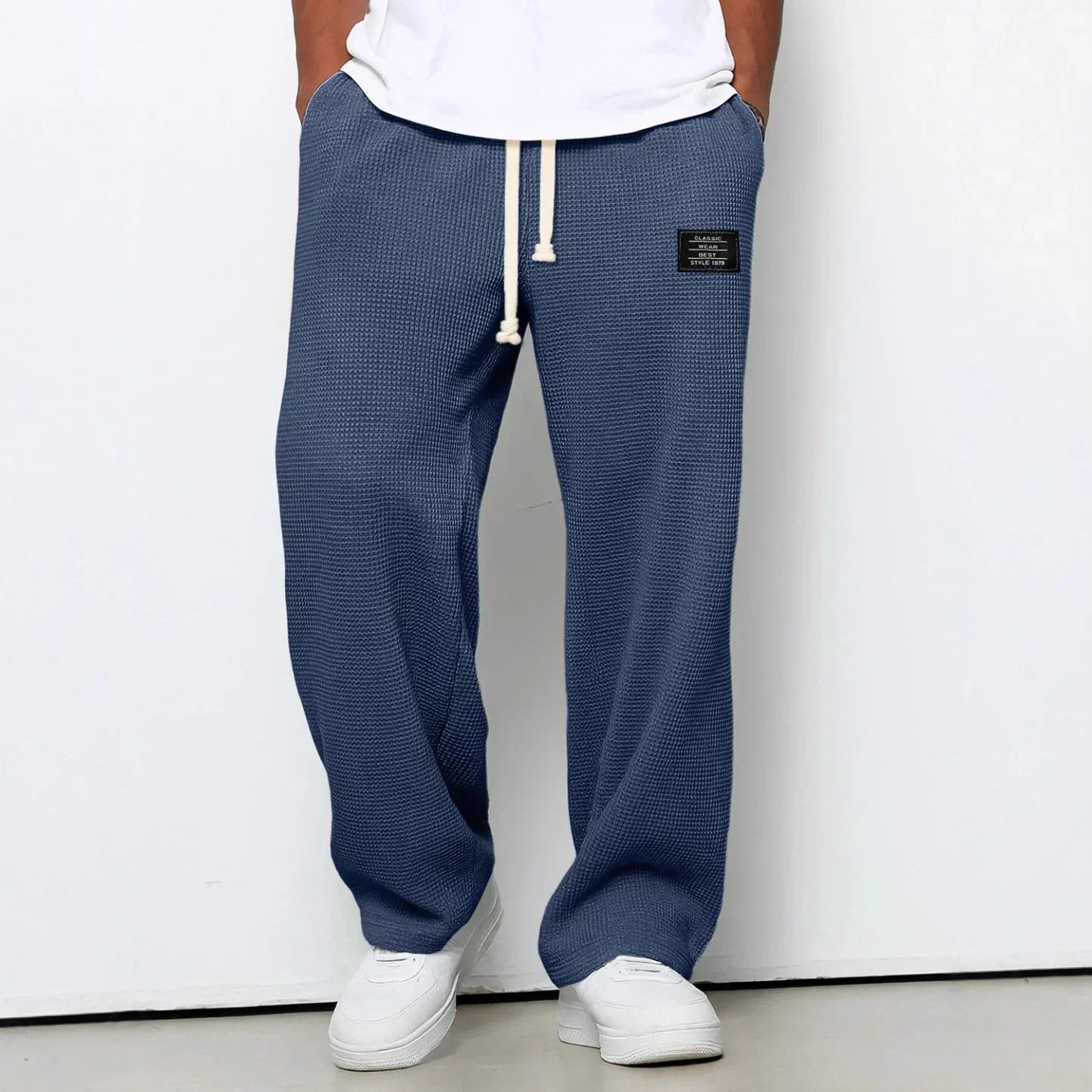 Blue waffle knit relaxed fit pants with drawstring waist, styled with white sneakers