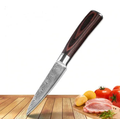 Damascus-style kitchen knife with dark wood handle on wooden surface near sliced vegetables and meat