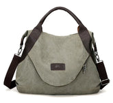 Olive green canvas shoulder bag with brown leather trim and adjustable strap, relaxed fit.