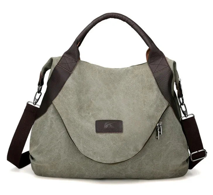 Olive green canvas shoulder bag with brown leather trim and adjustable strap, relaxed fit.