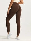 Brown high-waisted leggings with ruched back, form-fitting stretch fabric, paired with white sneakers