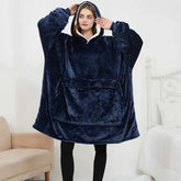 Woman wearing oversized navy blue plush hoodie blanket with front pocket, relaxed fit