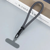 Gray nylon tech lanyard with metal clip and T-shaped attachment on light surface