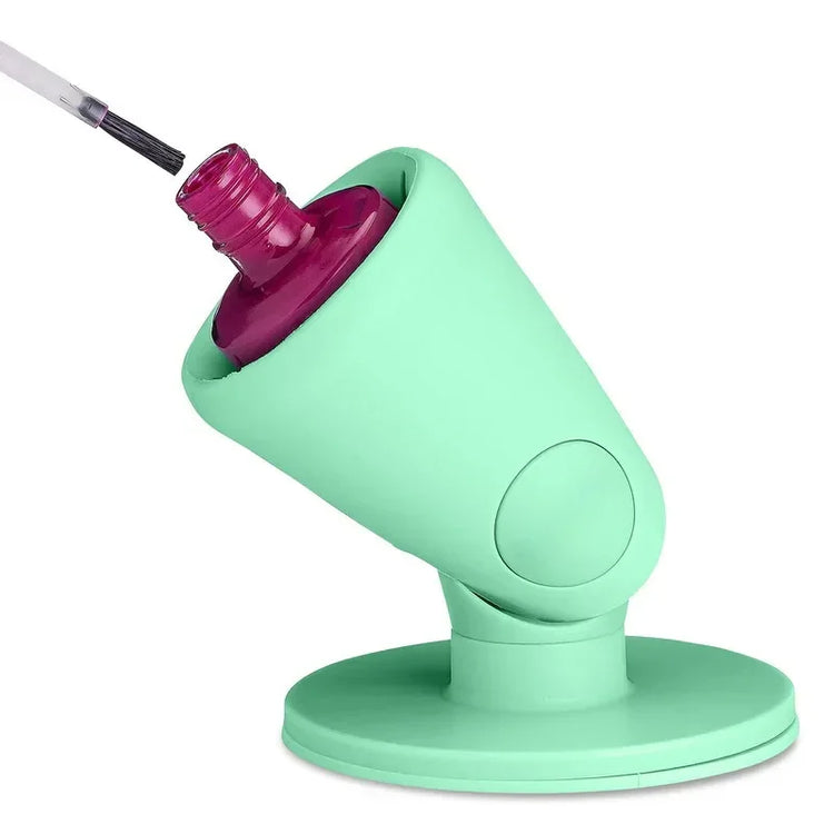 Green silicone nail polish holder with angled grip, holding pink nail polish bottle