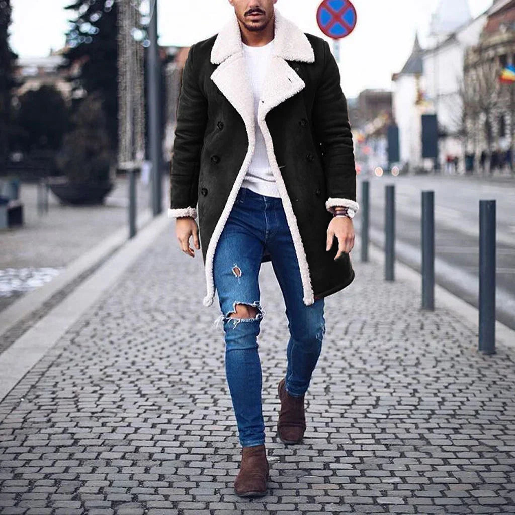 Man wearing a black shearling coat, distressed skinny jeans, and brown suede boots