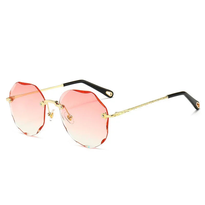 Round rimless sunglasses with wavy pink gradient lenses, gold metal arms, and black tips.