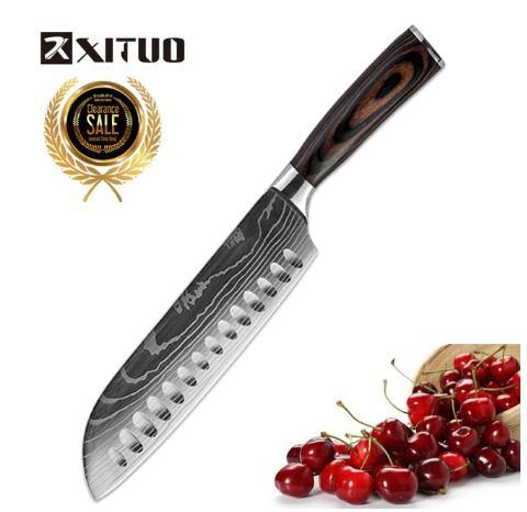 Santoku chef knife with patterned steel blade, dark wood handle, and fresh cherries on the side