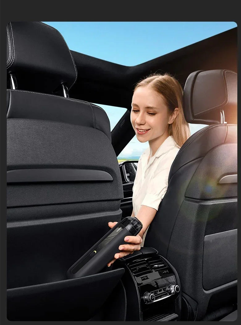 Woman in a short-sleeve white shirt using a portable black vacuum in a car interior