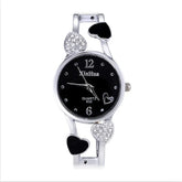 Silver wristwatch with black dial, heart-shaped accents, crystal details, and slim metal band