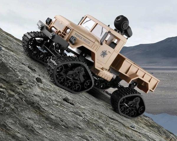 Beige off-road toy truck with rugged tank tracks climbing rocky terrain