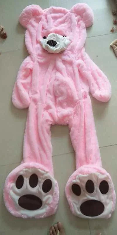 Pink plush bear onesie with paw print feet, full-body, soft and oversized fit