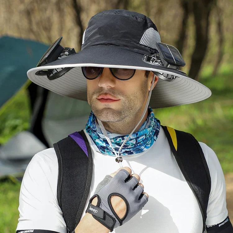 Man wearing futuristic wide-brim tech sun hat, sporty white shirt, fingerless gloves, patterned neck gaiter, and sunglasses outdoors.