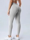 Light gray high-waisted leggings with ruched back, slim fit, stretchy fabric, paired with white sneakers
