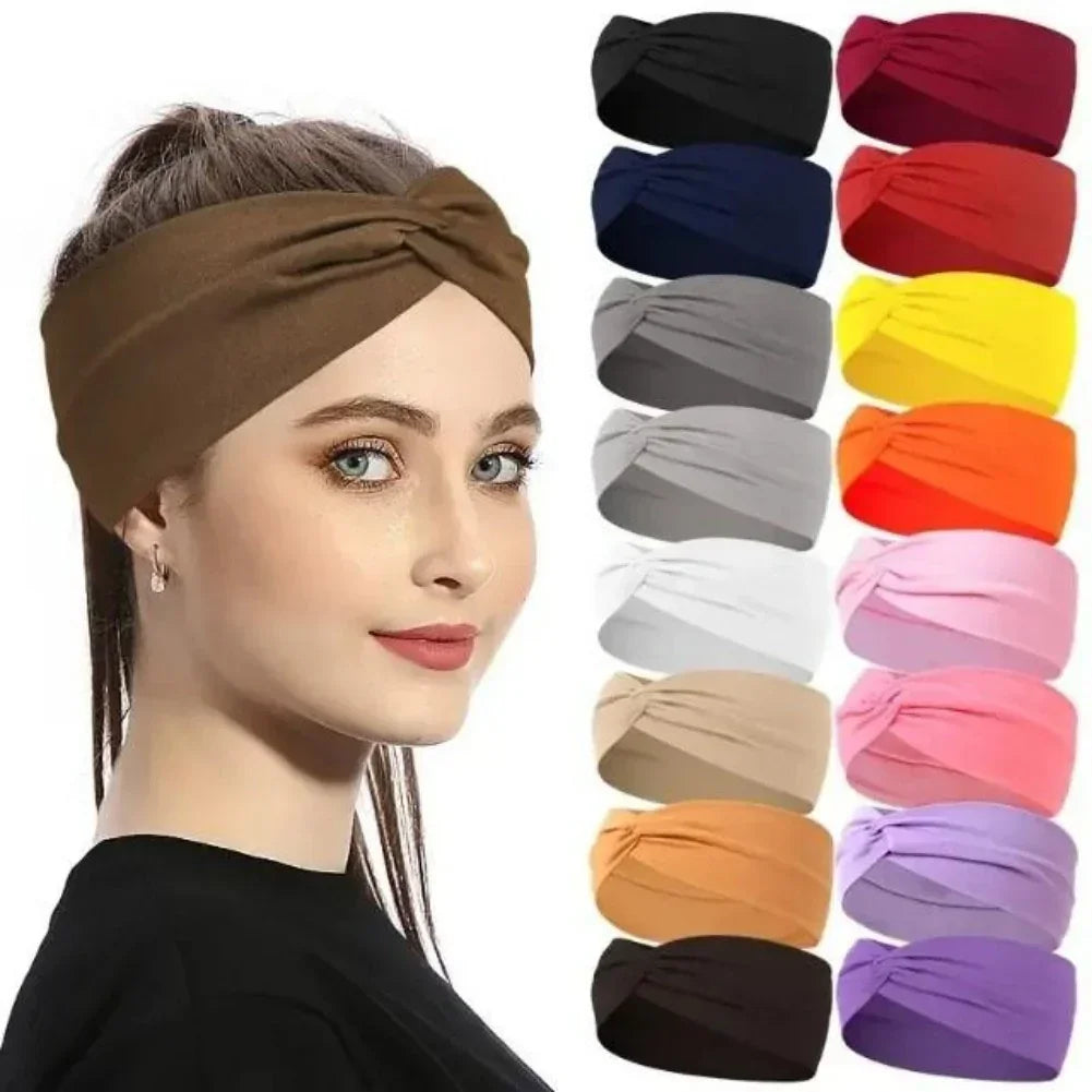Woman wearing a wide brown fabric headband, with multiple colors of the same twisted style headband displayed beside her.
