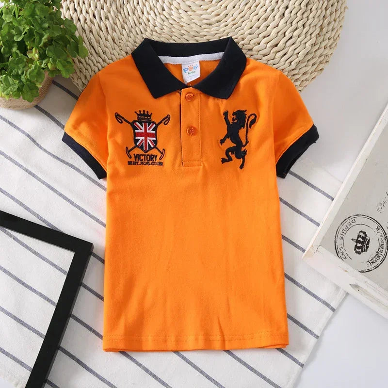 Orange cotton polo shirt with navy collar, crest embroidery, and slim fit style for kids