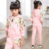 Girl wearing a light pink floral tracksuit set with zip-up hoodie and jogger pants, relaxed fit.