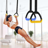Woman in sporty white crop top and black shorts performing suspension training indoors