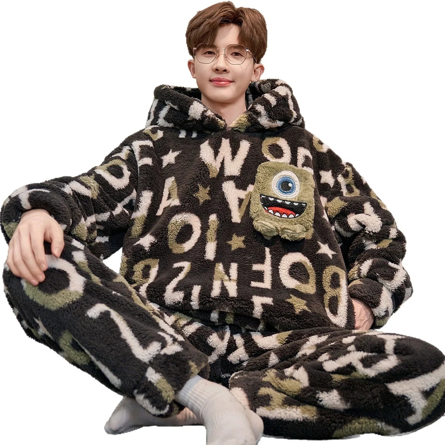 Man wearing oversized fuzzy loungewear set with black, white, and green letter print, cartoon patch, relaxed fit.