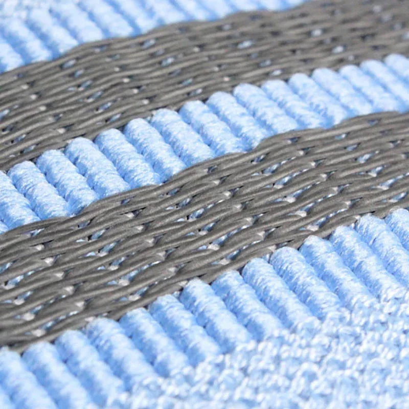 Close-up of light blue ribbed fabric with gray woven stripes, soft textured knit material