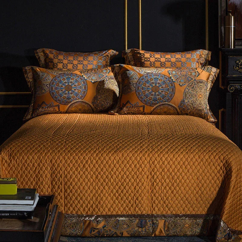 Gold satin bedding set with quilted texture and ornate geometric patterned pillowcases.