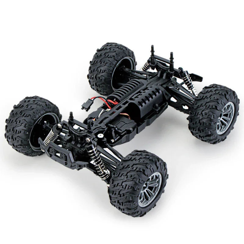 Black off-road RC car chassis with large rugged tires and exposed suspension system