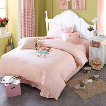 Light pink bedding set with cartoon illustration, soft cotton material, cozy fit, in a pastel bedroom.