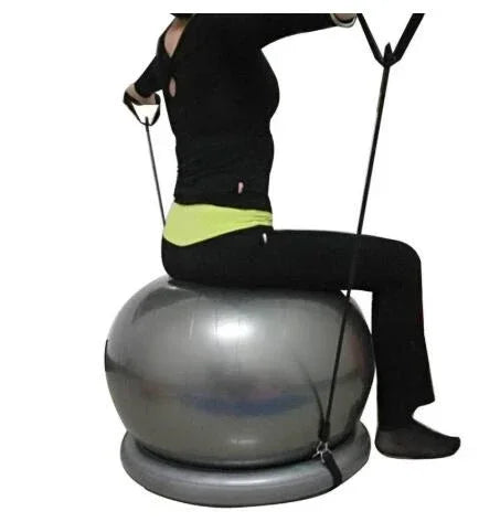 Woman in black fitted activewear sitting on silver exercise ball with resistance bands