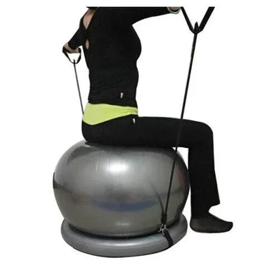 Woman in black fitted activewear sitting on silver exercise ball with resistance bands