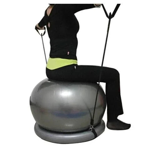 Woman in black fitted activewear sitting on silver exercise ball with resistance bands