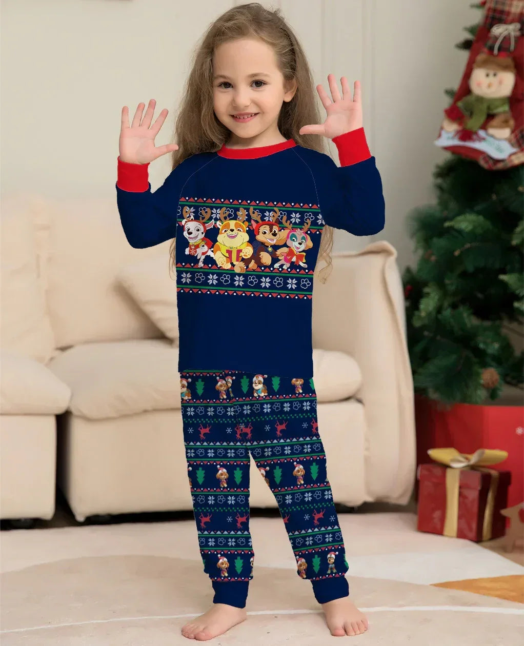 Child wearing navy blue holiday pajamas with red cuffs, cartoon animal print, and festive patterns