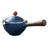 Blue ceramic saucepan with wooden handle and matching lid on white background