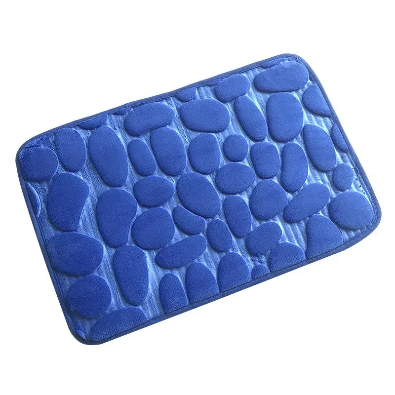 Blue rectangular bath mat with raised pebble pattern and soft fabric texture