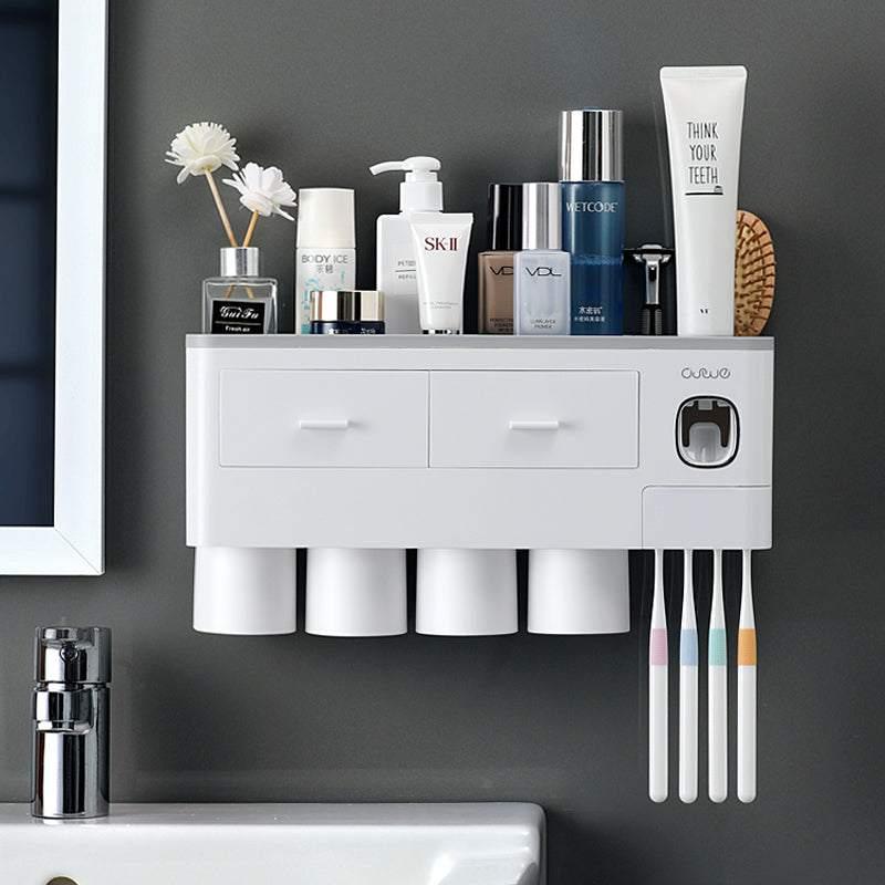 Modern wall-mounted white bathroom organizer with cups, toothbrushes, toiletries and drawers.