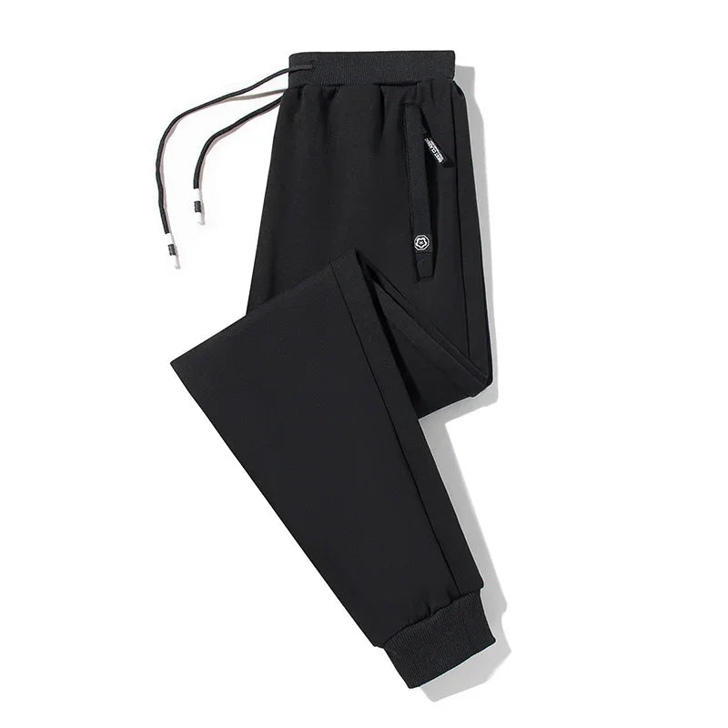 Black streetwear jogger pants with drawstring waist, tapered fit, and ribbed cuffs