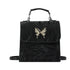 Black faux leather backpack with metallic butterfly accent, structured fit, top handle and shoulder straps