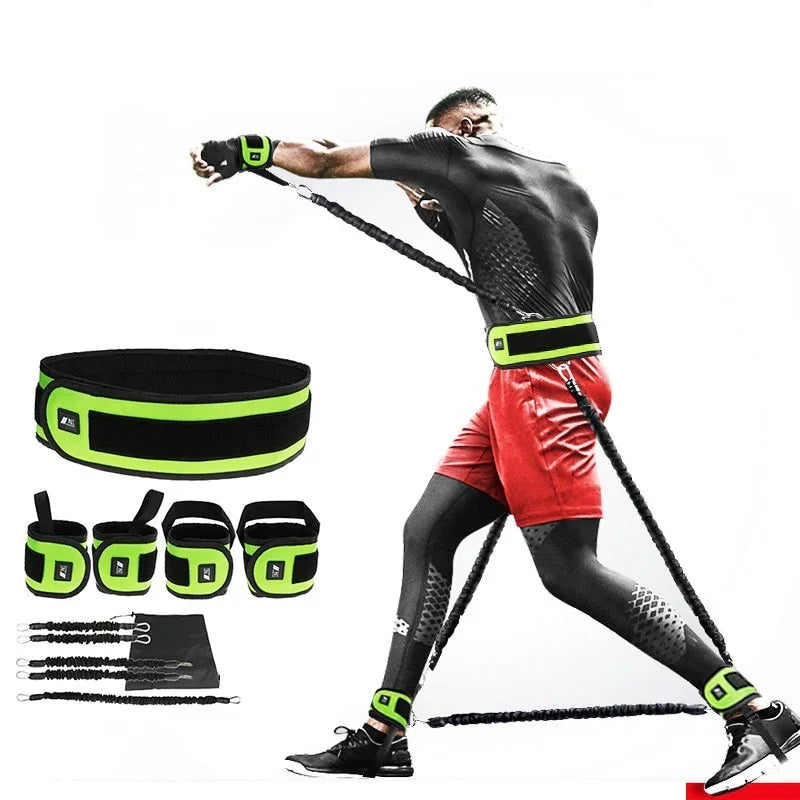 Man wearing black compression top, red athletic shorts, black leggings, and fluorescent green resistance training bands for fitness workout.