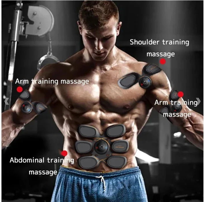 Muscular man wearing black EMS muscle stimulators on arms, shoulders, and abs in gym setting