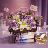 Artificial purple and white flower arrangement with LED fairy lights in a decorative box