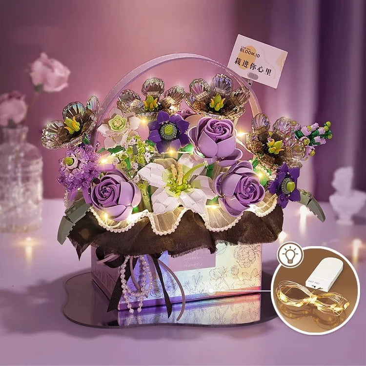 Artificial purple and white flower arrangement with LED fairy lights in a decorative box