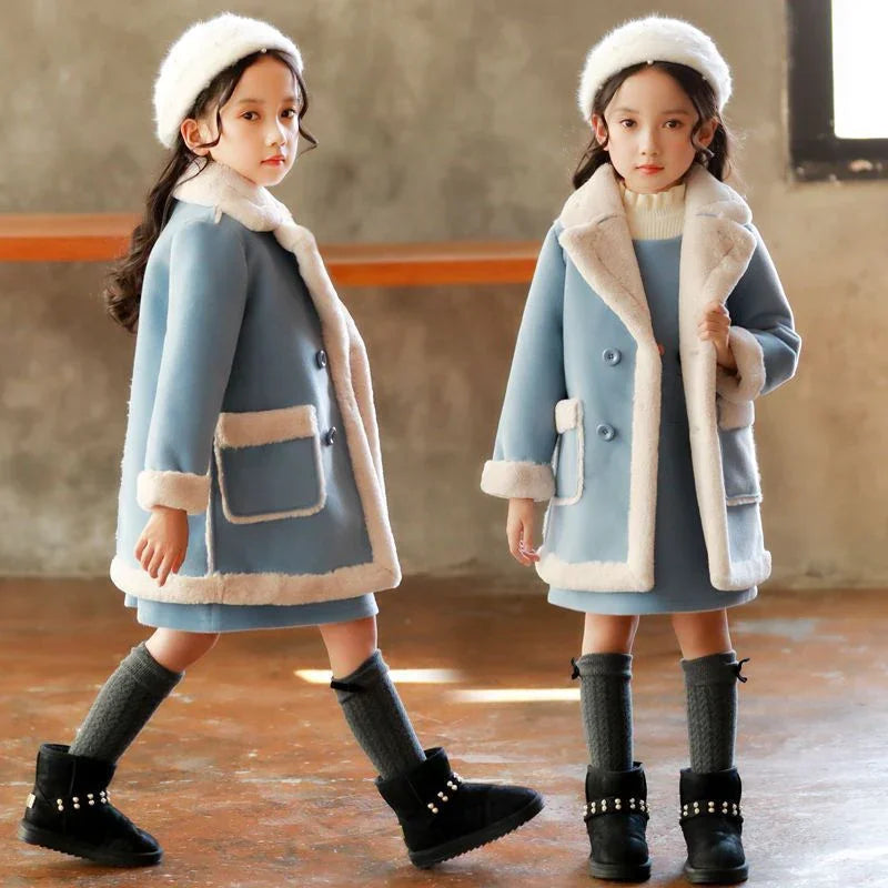 Girls in blue faux fur trim winter coats, matching dresses, and knit hats