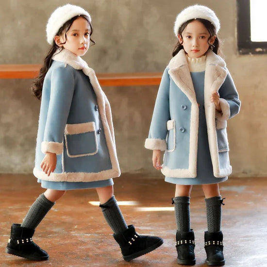 Girls in blue faux fur trim winter coats, matching dresses, and knit hats