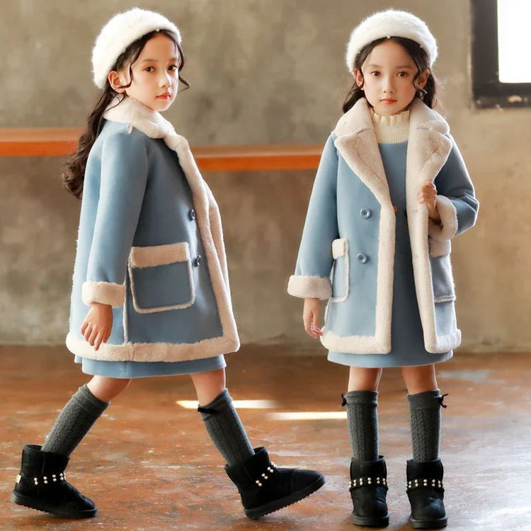 Girls in blue faux fur trim winter coats, matching dresses, and knit hats
