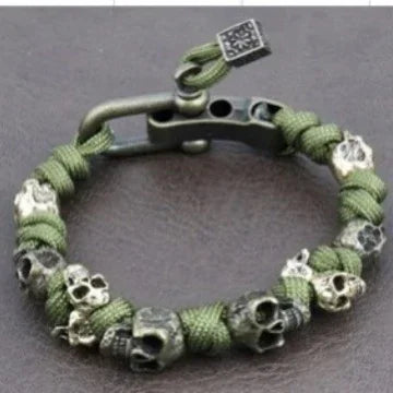 Green paracord bracelet with metal skull accents and matte black clasp, rugged streetwear style