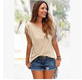 Woman in beige fringe sleeve top and denim shorts, casual summer streetwear style