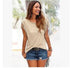 Woman in beige fringe sleeve top and denim shorts, casual summer streetwear style