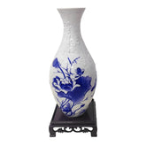 Blue and white ceramic vase with floral design, puzzle pattern, on wooden stand