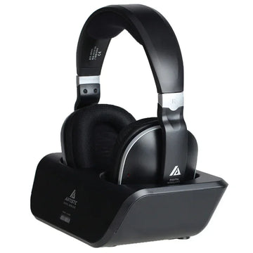 Black over-ear wireless headphones with padded ear cushions on a charging dock, matte finish
