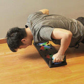 Man in a slim-fit grey athletic t-shirt using a push-up board on wooden floor