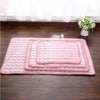 Soft pink quilted floor mats with bubble texture, layered on wood floor near window